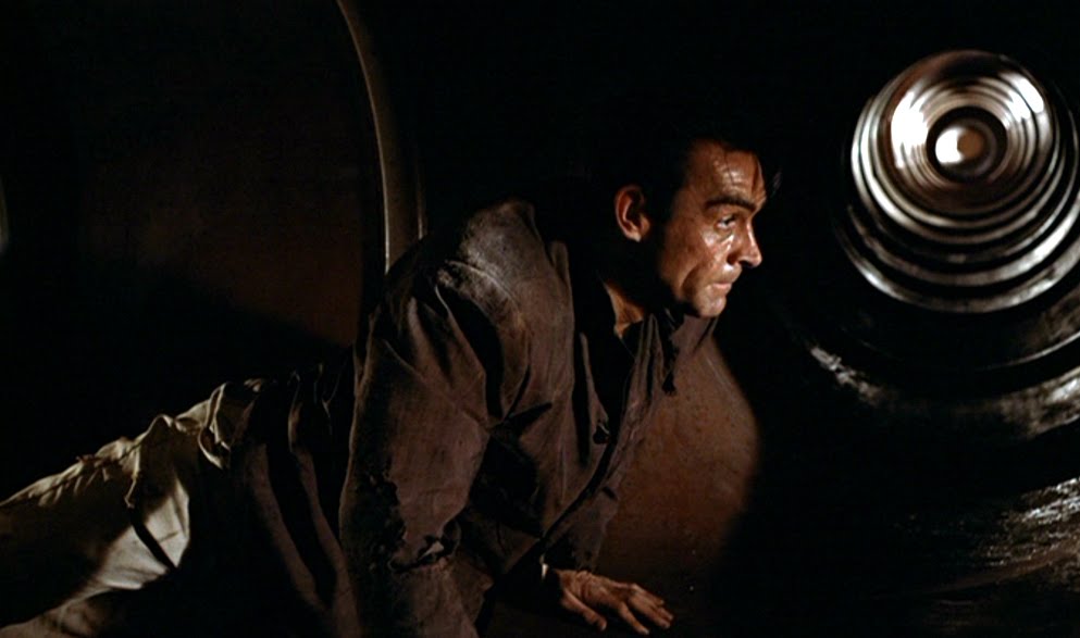 James Bond crawls through the ducts to escape Dr. No's prison - just as the fiendish doctor intended.